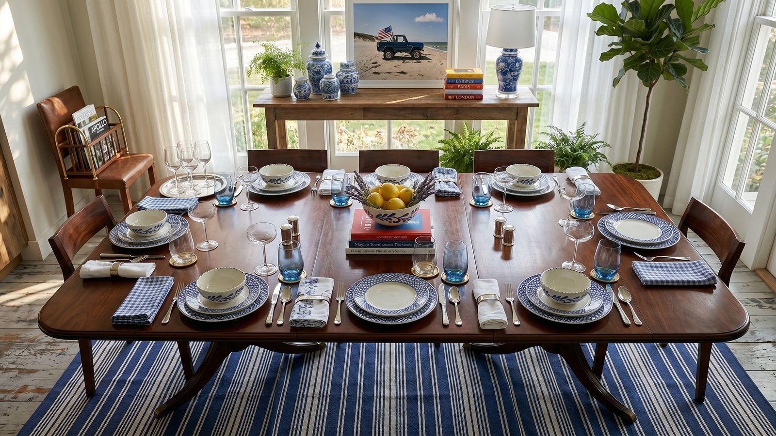 Dining table set for a meal with plates, glasses, and cutlery in a bright room.