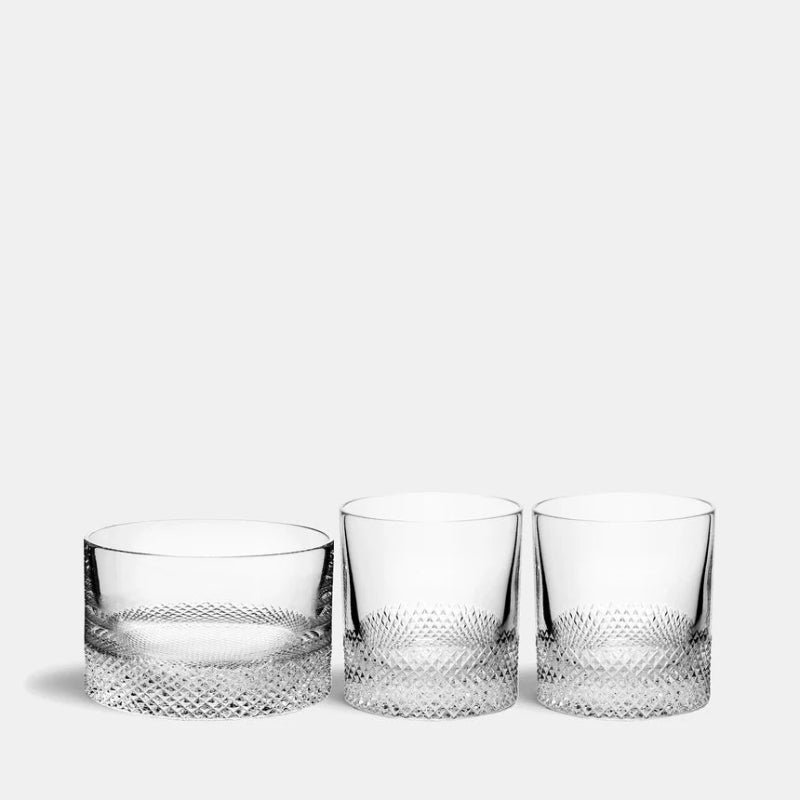 Three crystal glasses with textured designs on a white background