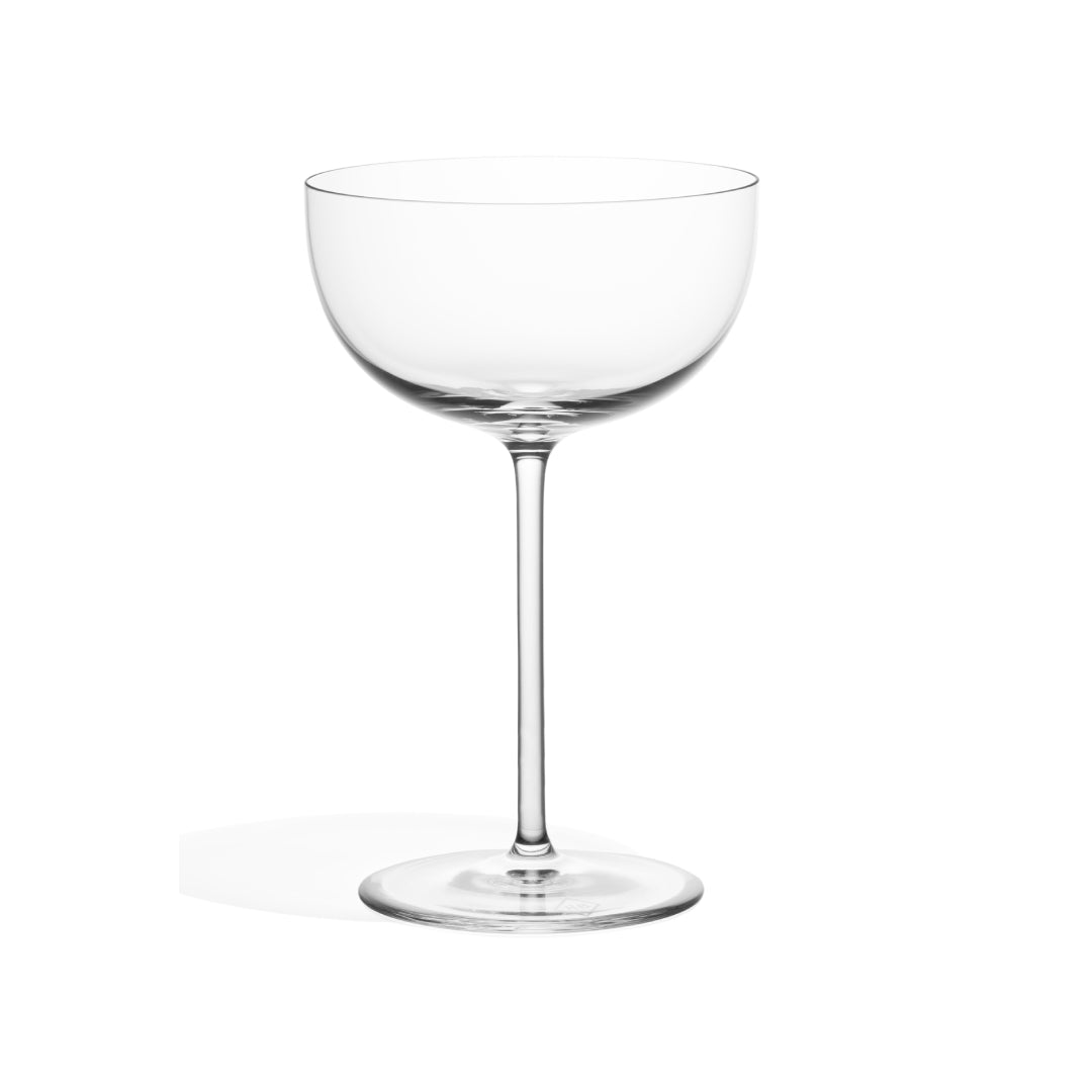A clear stemmed cocktail glass with a coupe shape on a white background.