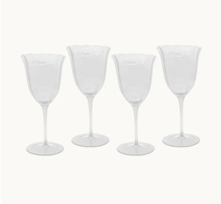 Set of four clear wine glasses on a white background