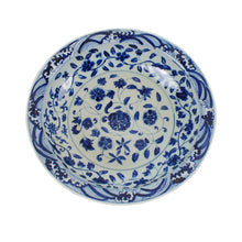 Blue and white floral ceramic plate on a white background
