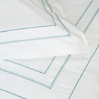 Close up of white pillowcases with blue embroidery