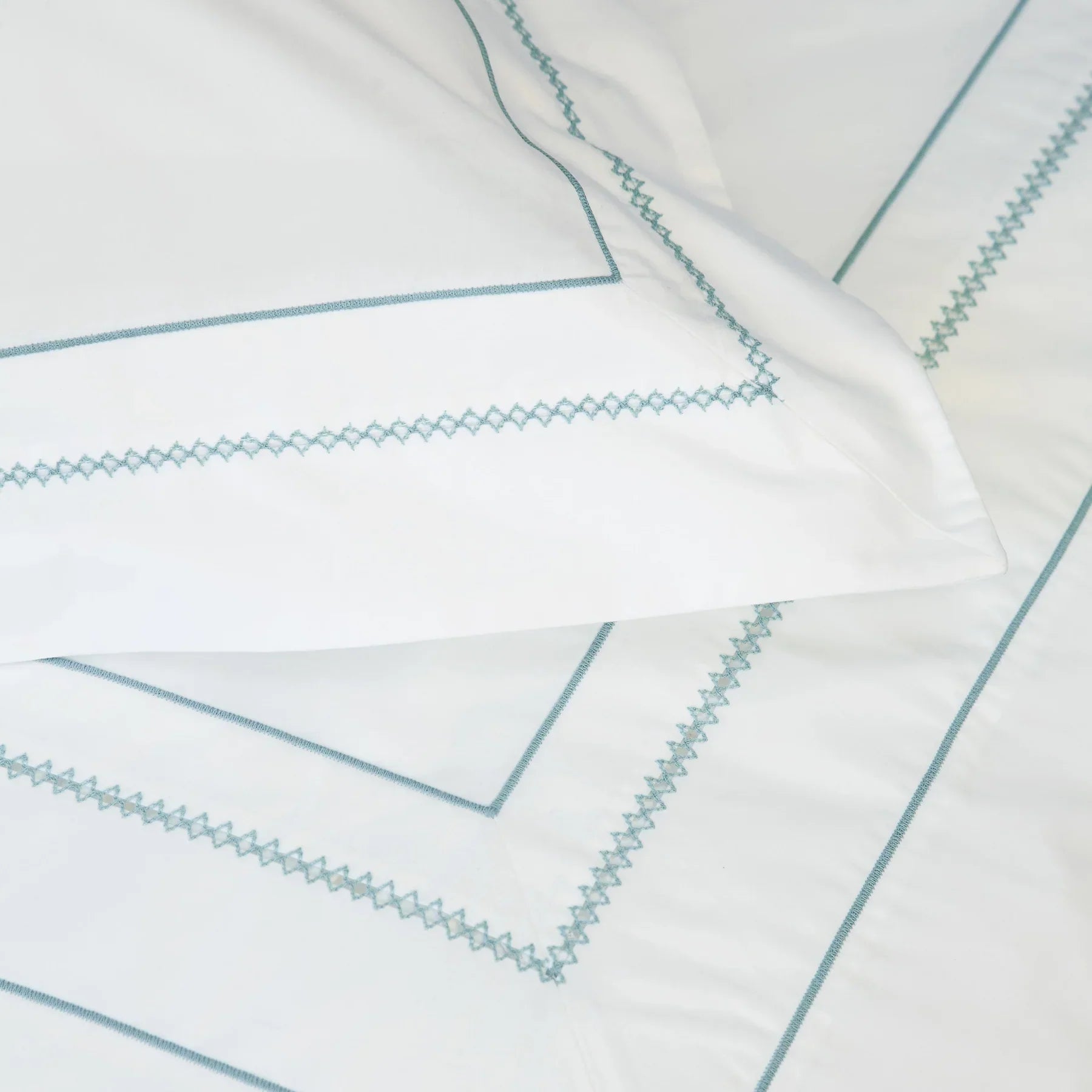 Close up of white pillowcases with blue embroidery