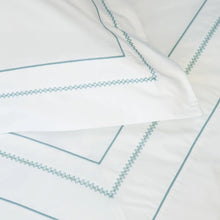 Close up of white pillowcases with blue embroidery