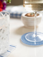 Glass of wine on a blue coaster with a blurred background