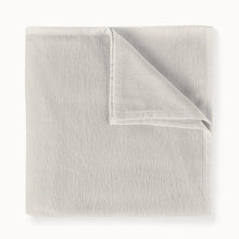 Folded light gray blanket on a white background
