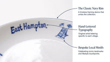 Close-up of a white ceramic plate or dish edge with blue 'East Hampton' lettering and blue architectural motif, with callout text explaining design features.