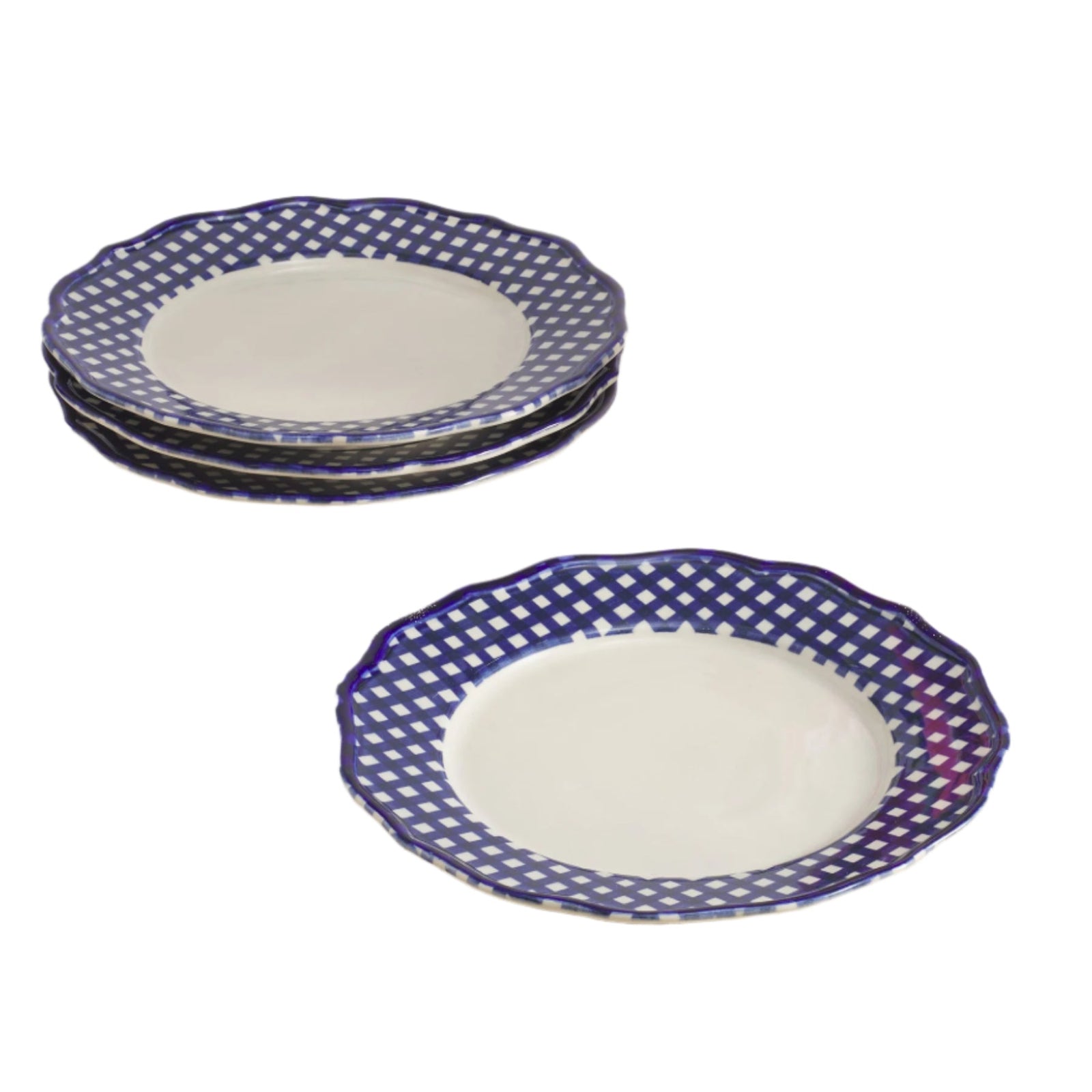 Set of four ceramic plates with blue decorative rims on a beige table