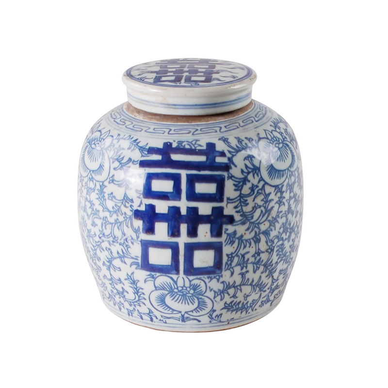 Blue and white ceramic jar with floral patterns and a lid on a white background