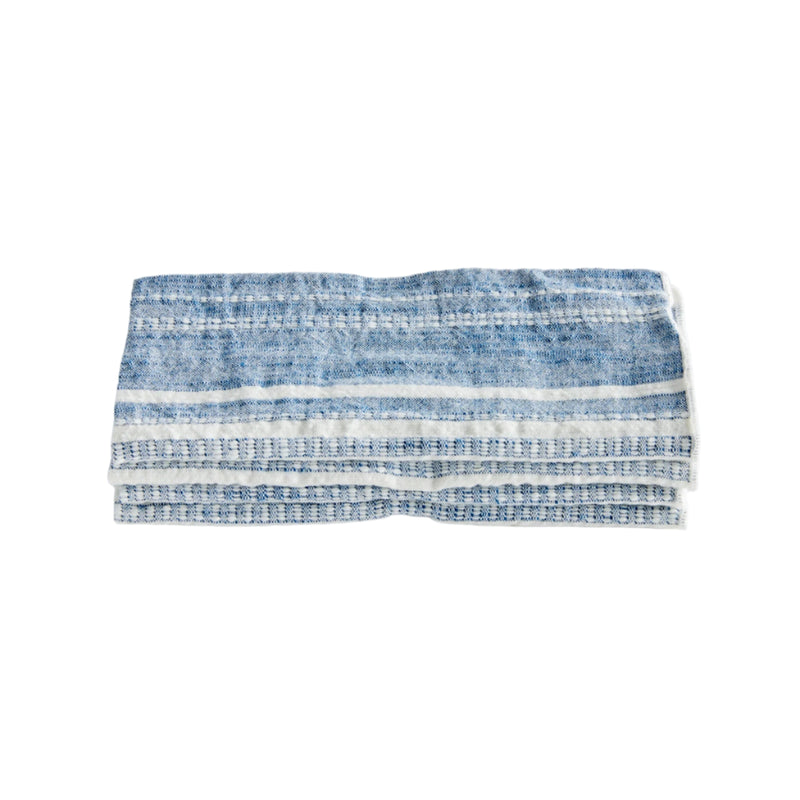 Folded blue and white striped fabric on a light gray background