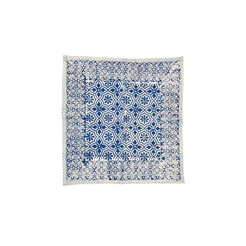 Blue and white patterned fabric square napkin on a white background