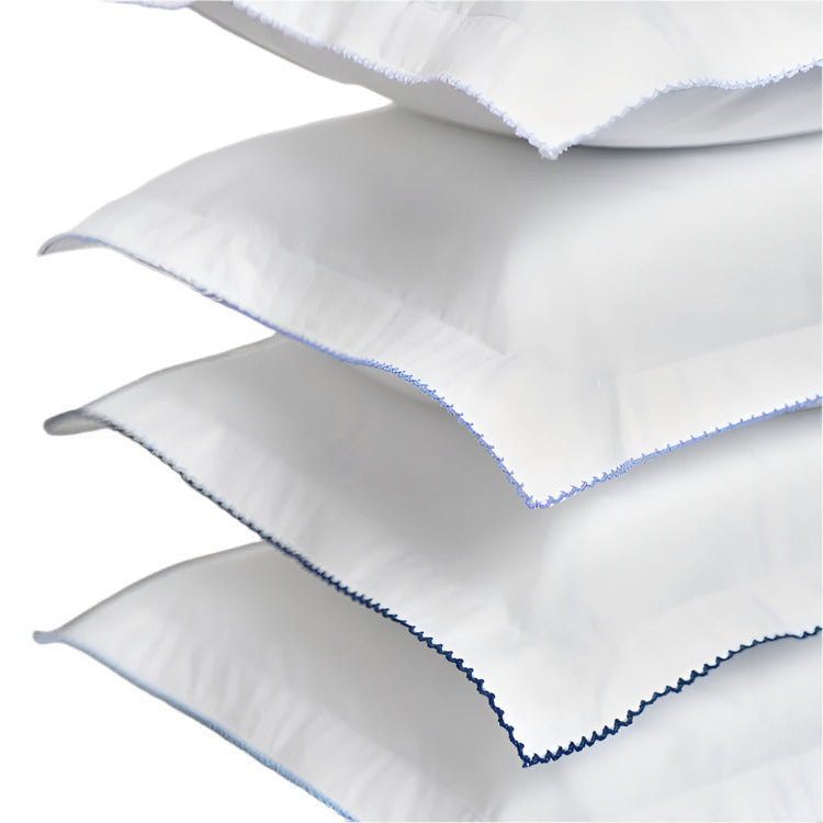 4 white fabric pillows with blue embroidery on a white background