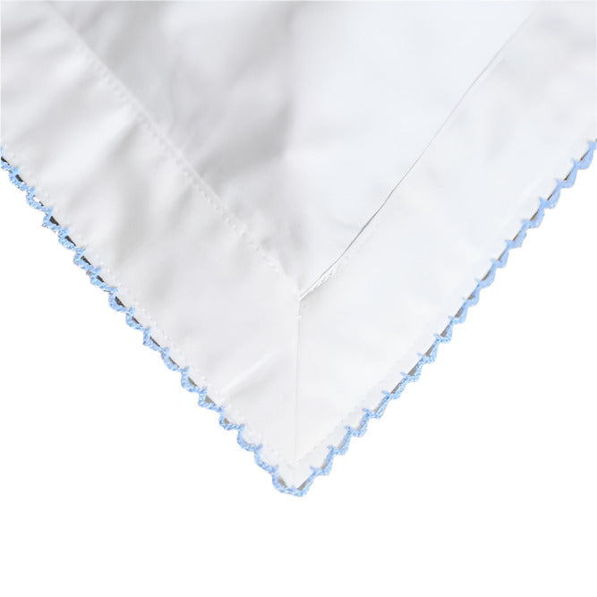 White fabric with blue embroidery on a white background