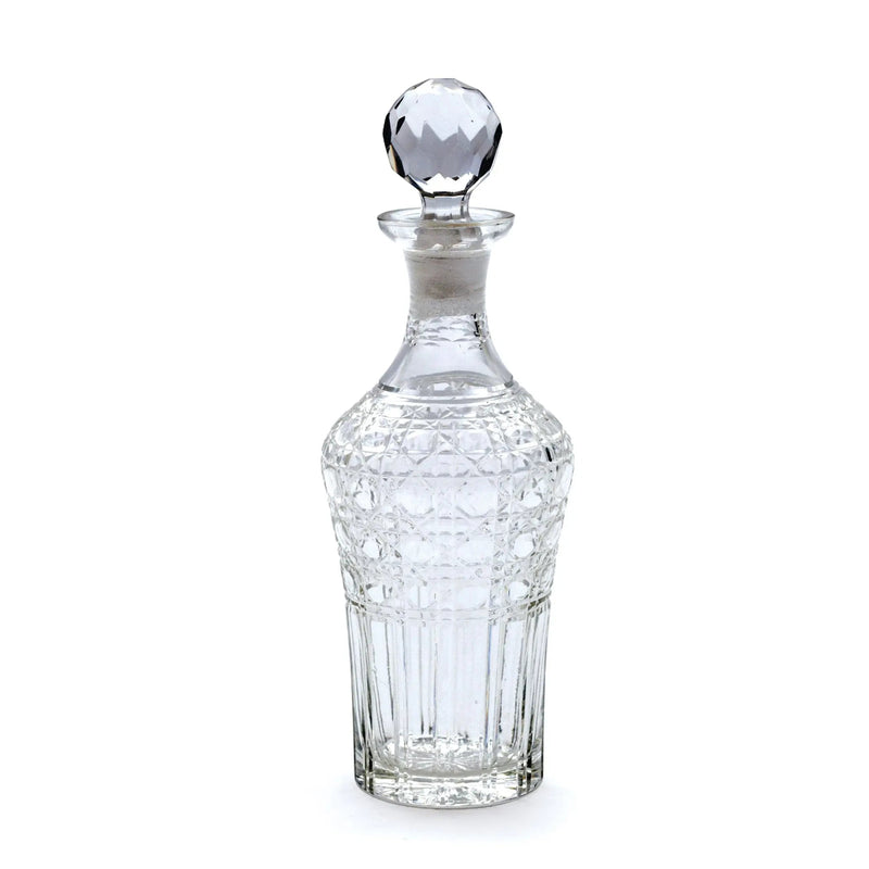 Clear glass decanter with a diamond-cut design on a white background