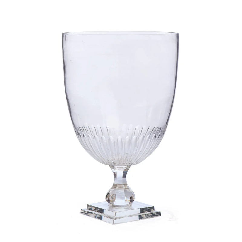 Clear glass goblet with a square base on a white background