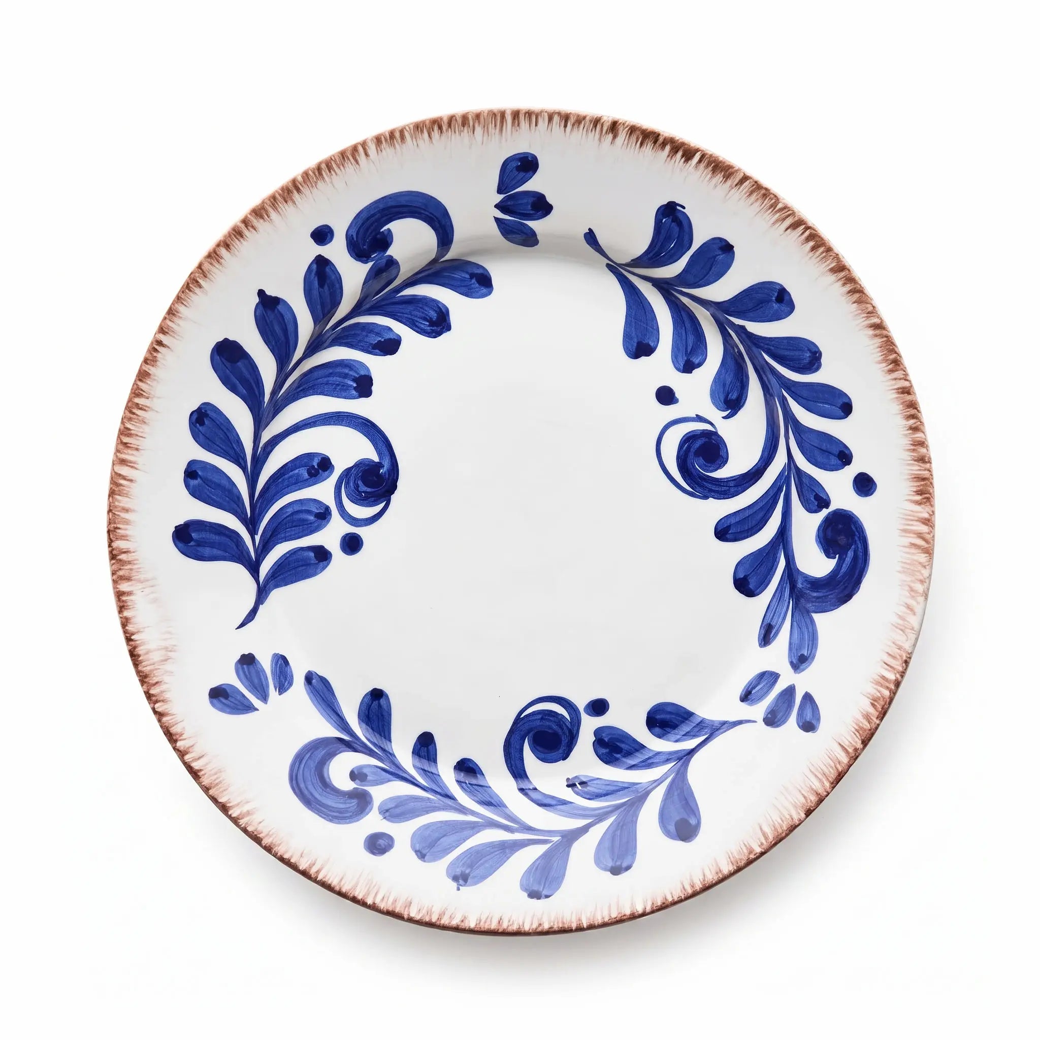 A round white ceramic plate with a rustic, hand-painted blue floral pattern and a textured, reddish-brown rim, shown from a top-down perspective on a white background.