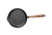Black cast iron skillet with a wooden handle on a white background