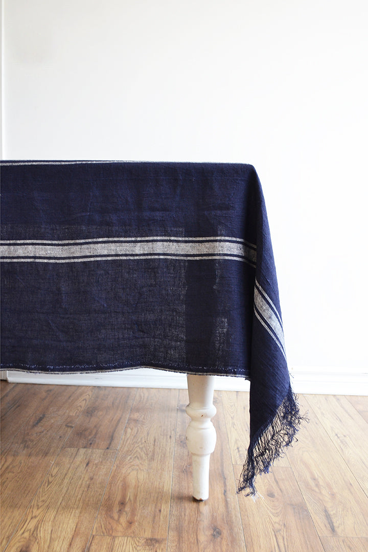 Linen navy tablecloth with a white stripe on a table