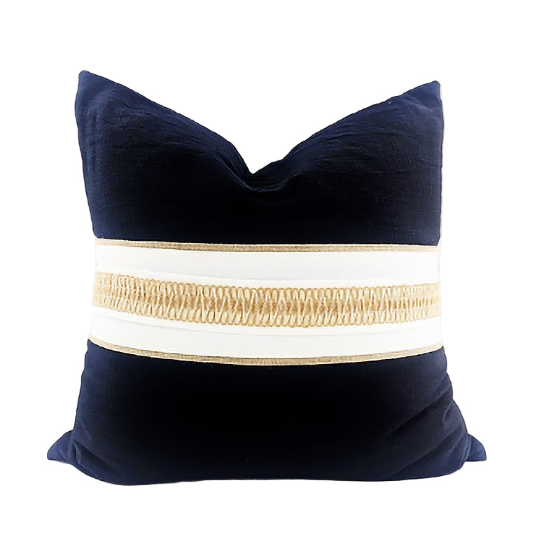 Navy blue pillow with a beige and white striped band on a white background
