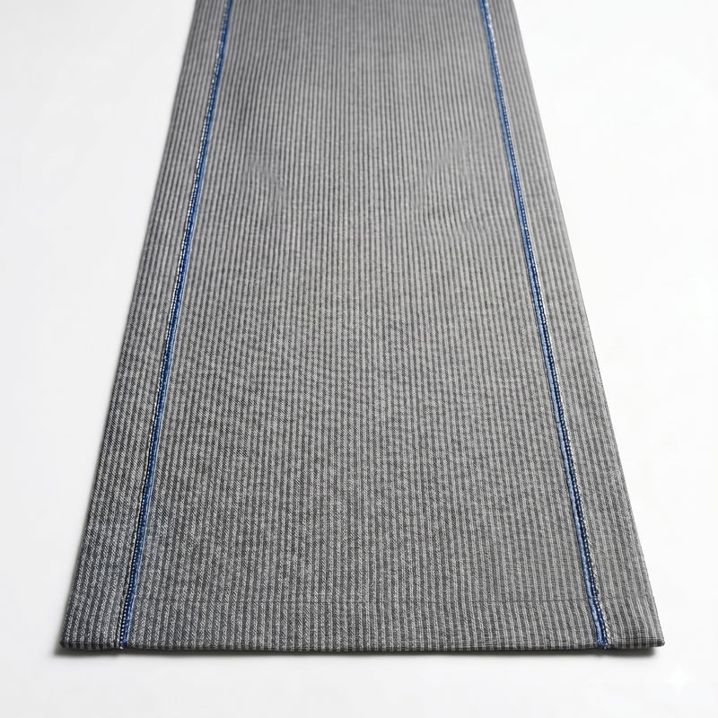 Gray textured rug with blue stitching on a white background