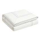 Folded white towel with blue hem on a light gray background