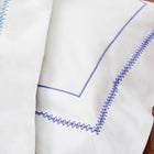 Close up of white pillowcase with blue embroidery