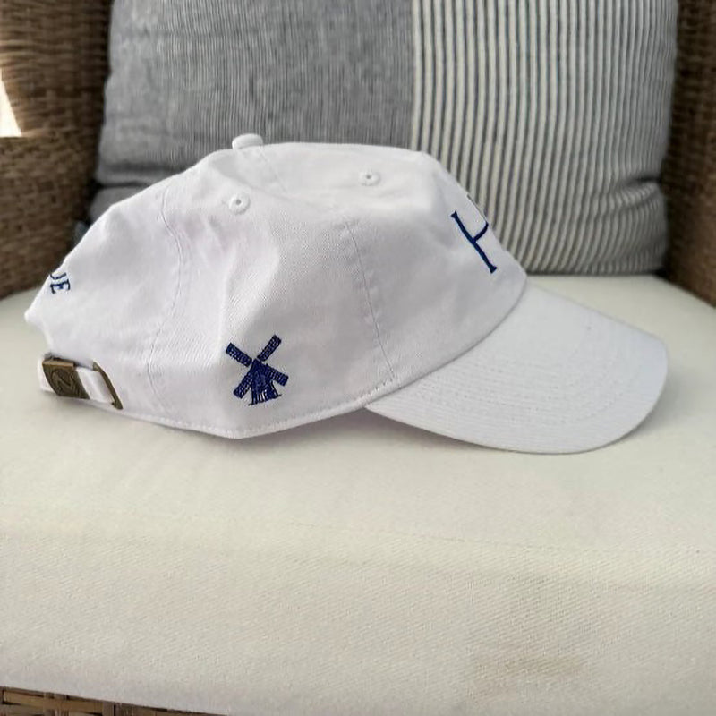 A white baseball cap with a blue windmill logo on the side.