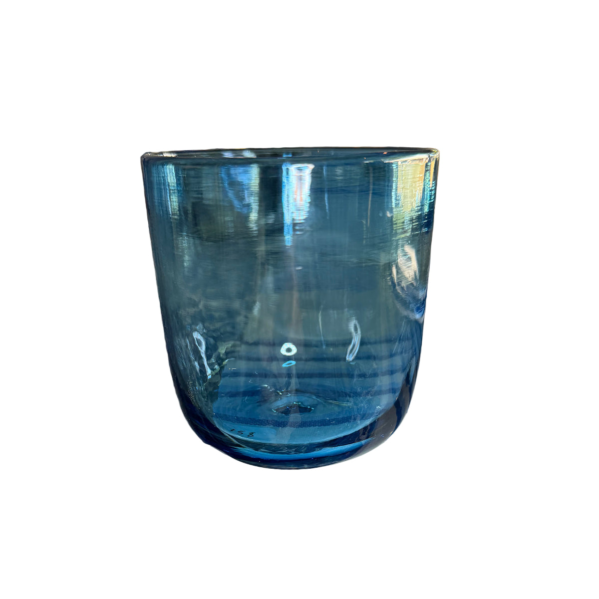 Blue glass object on a patterned surface with outdoor elements in the background