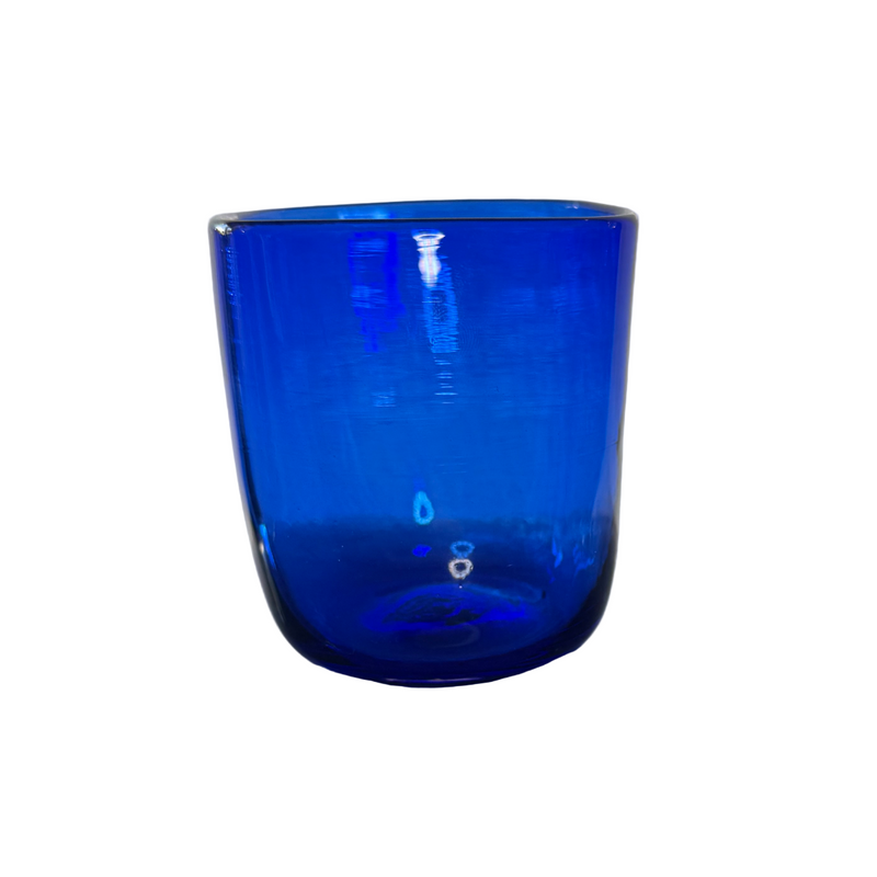 Blue glass tumbler on a reflective surface with a neutral background