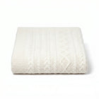 White cable knit blanket on a white background