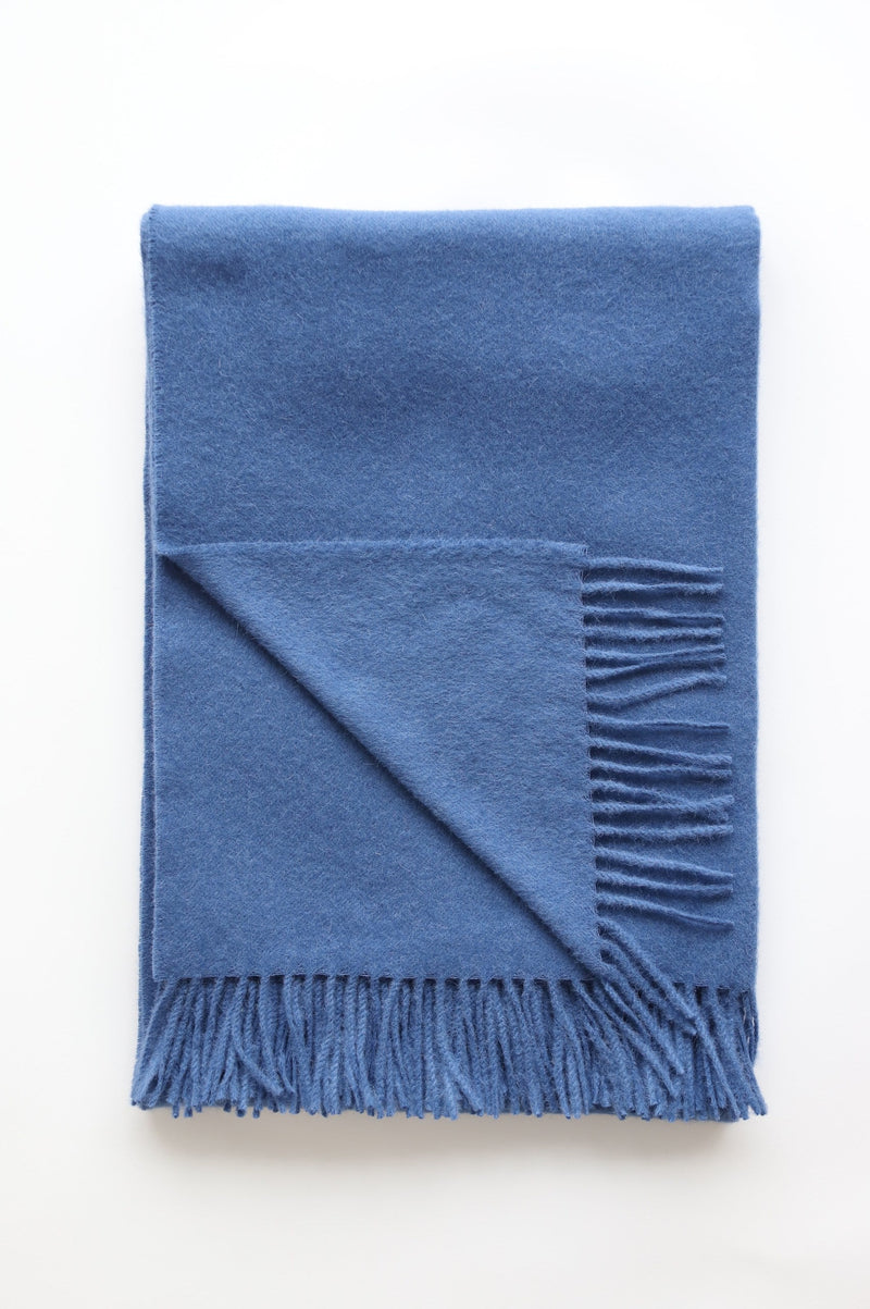 Blue alpaca shawl with fringe on white background