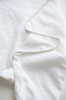 Close-up of a white textured sheet with a subtle stripe
