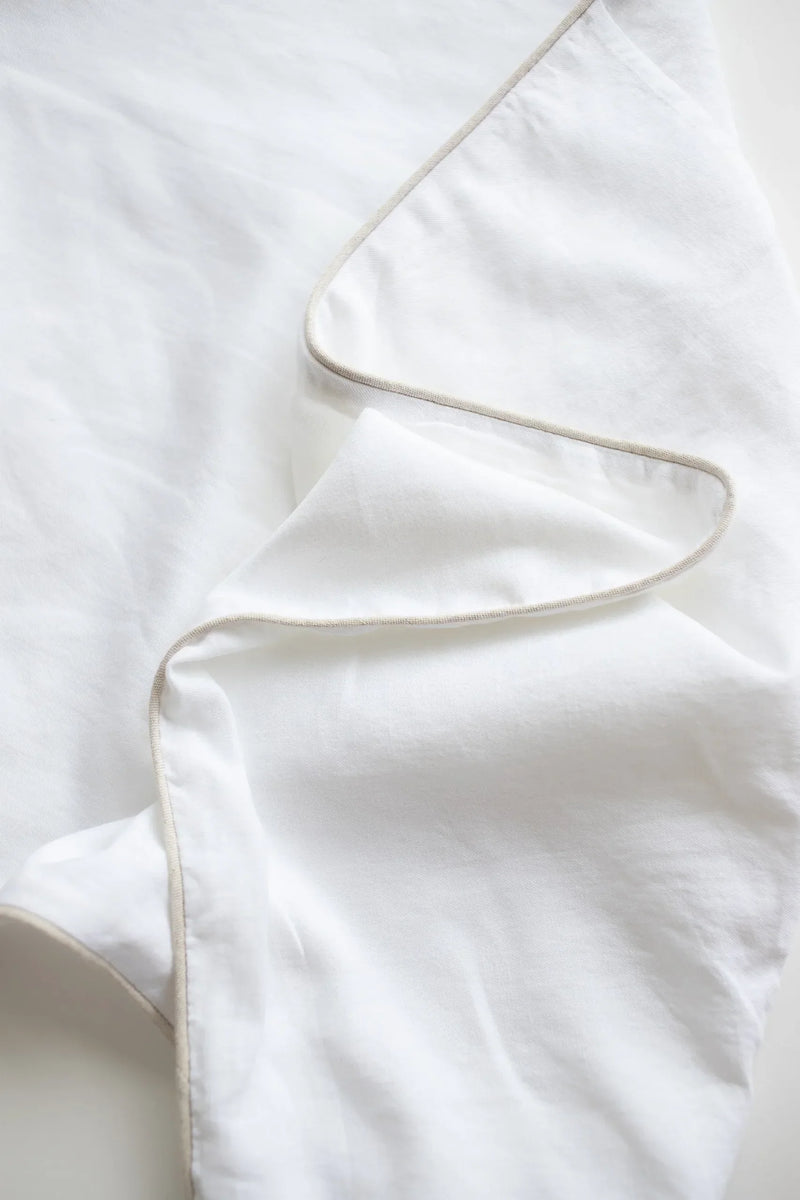 Close-up of a white textured sheet with a subtle stripe