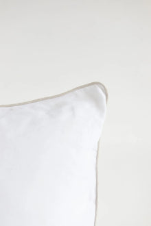 White pillow with a thin beige border on a white background