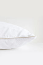 White pillow with a thin beige line on a white background