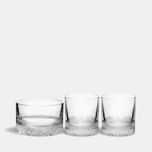 Three crystal glasses with textured designs on a white background
