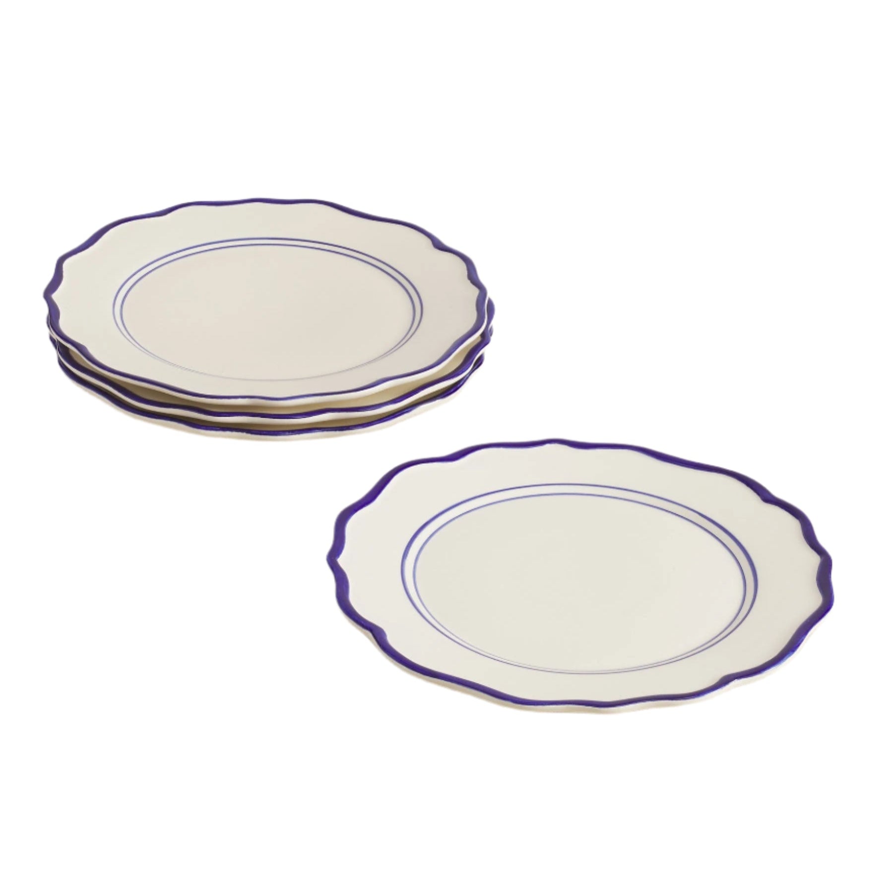 Set of 4 white dinner plates with blue rims on a beige surface