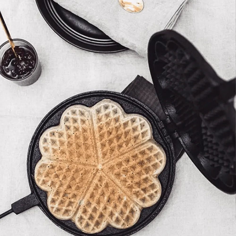 Waffle maker with a cooked waffle on a light gray surface