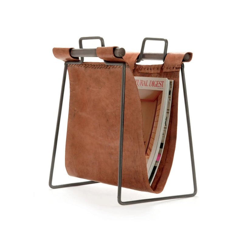 Brown leather magazine holder with metal legs on a white background