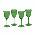 Four green glass goblets on a white background