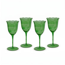 Four green glass goblets on a white background