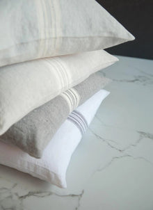Four striped pillows on a marble surface