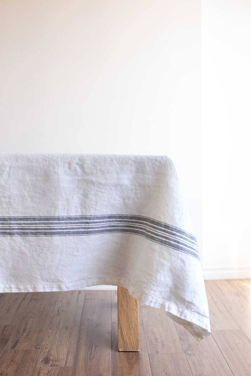 White linen tablecloth with  blue stripes on table
