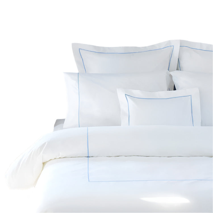 White bedding set with blue piping on a white background