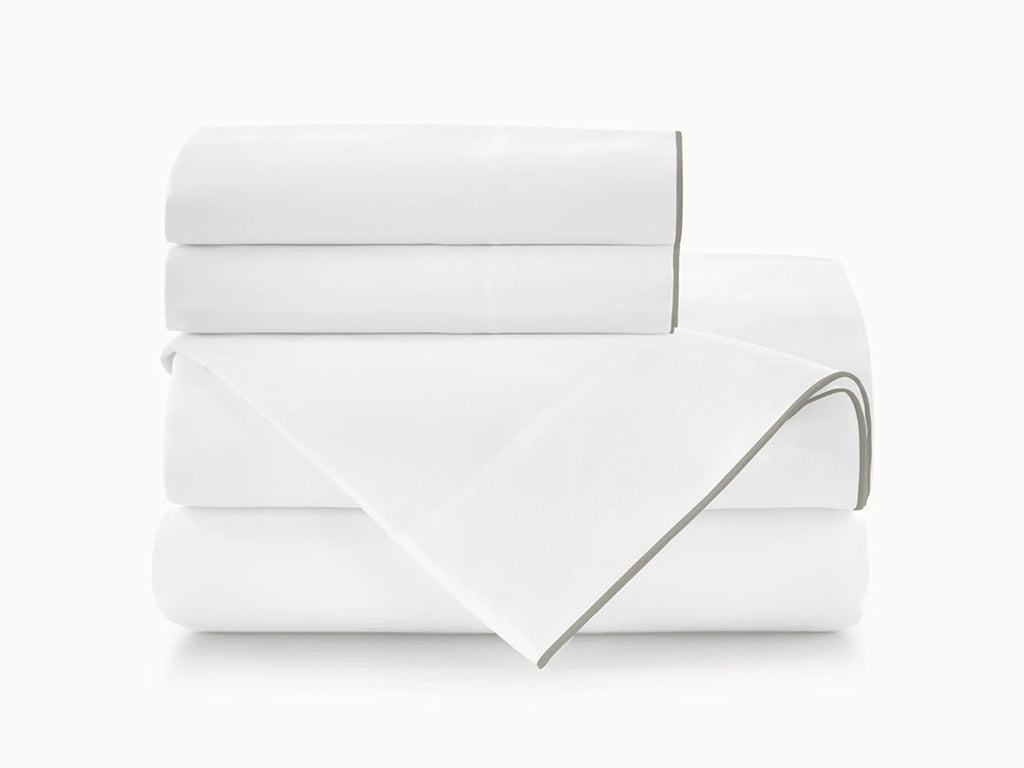 Folded white blanket with gray trim on a white background