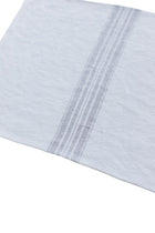 Close-up of a light blue fabric with a subtle pattern on a white background
