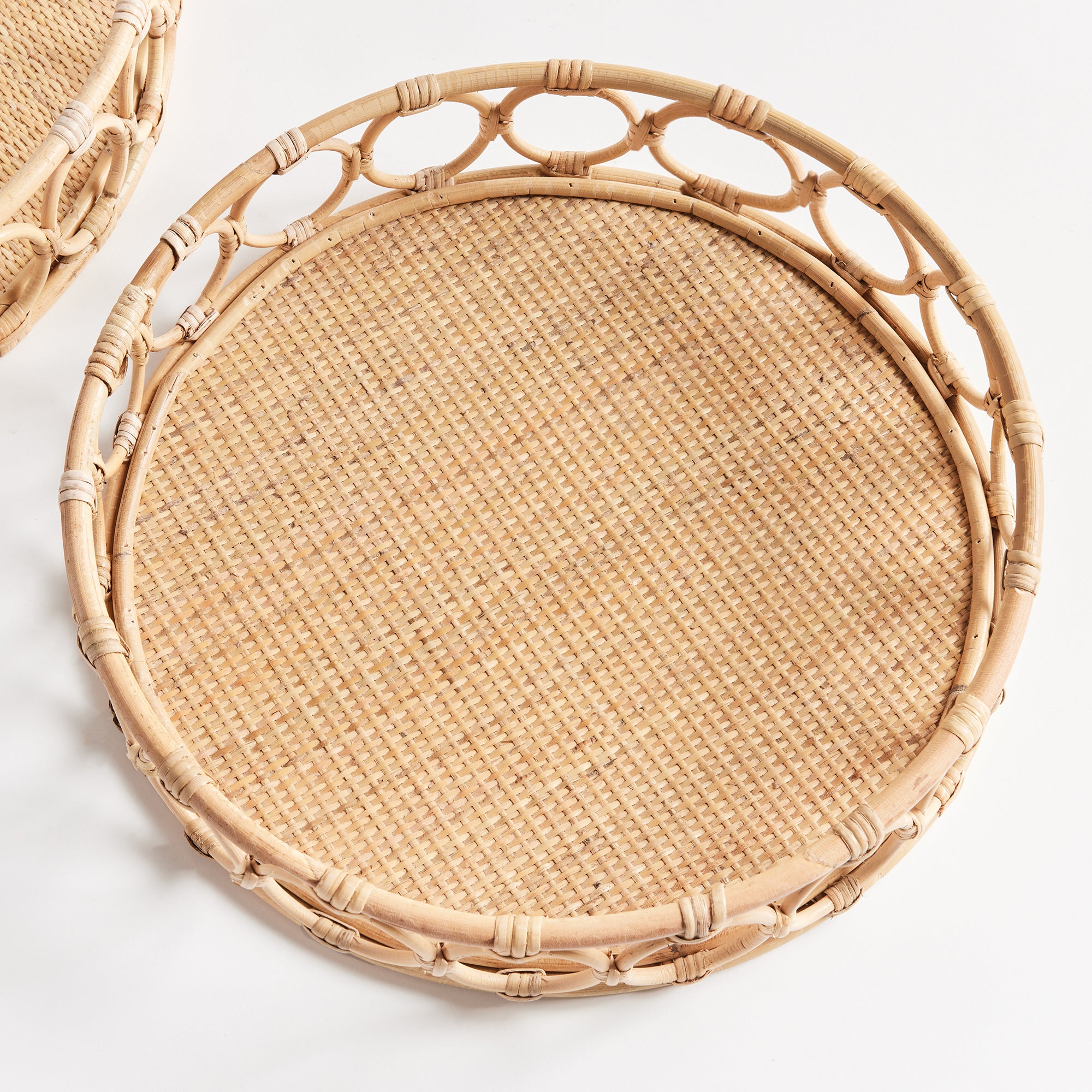 Top view of circular woven tray with circles around edge on white background