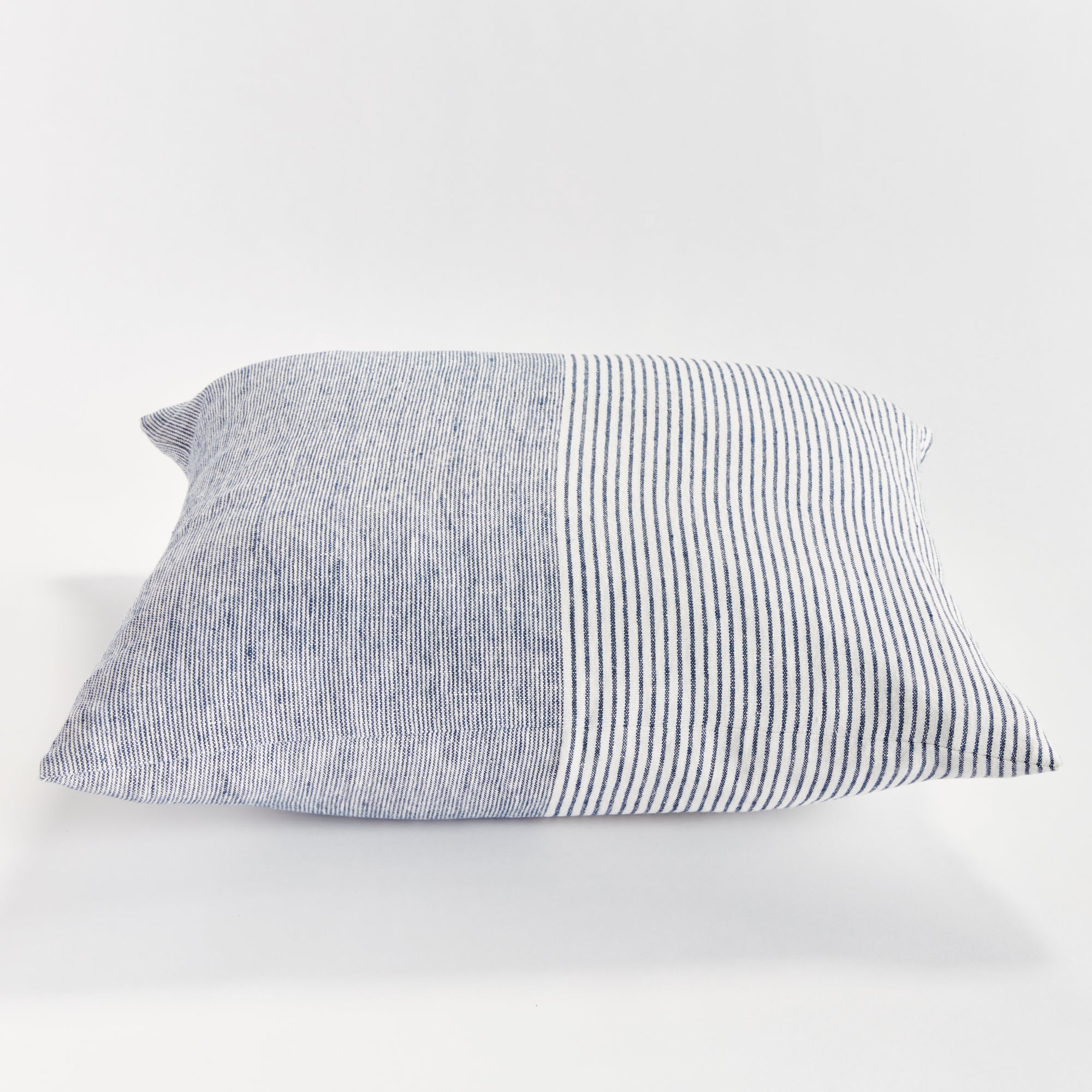 Square pinstripe pillow in blue and white on a white background