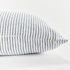 Close up of rectangular pillow with thin blue stripes on white background