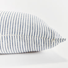 Close up of rectangular pillow with thin blue stripes on white background